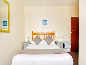 
A bed or beds in a room at OYO Godolphin Arms Hotel
