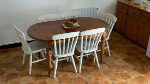 uma mesa de madeira com quatro cadeiras brancas à volta em Mill House - Devon Holiday Accommodation em Sidmouth