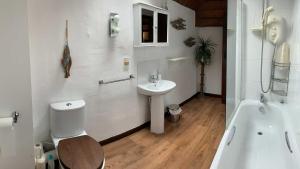 uma casa de banho com um lavatório, um WC e uma banheira em Mill House - Devon Holiday Accommodation em Sidmouth