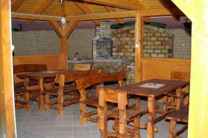 a dining room with wooden tables and chairs and a kitchen at Chata ALBA REGIA in Jahodná