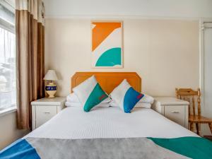 a bedroom with a bed with blue and white pillows at OYO Godolphin Arms Hotel in Newquay