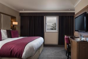 ein Hotelzimmer mit einem großen Bett und einem Fenster in der Unterkunft Radstone Hotel in Larkhall
