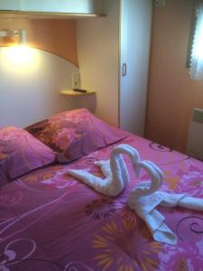 two swans laying on top of a bed at Les Jardins du castel gites Annick et Jean paul in Saint-Georges-dʼEspéranche