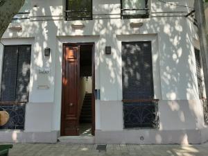 a white building with a brown door and windows at Fado 103 in Colonia del Sacramento