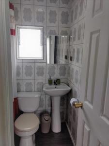 a bathroom with a toilet and a sink and a window at Departamentos Egaña in Puerto Montt +24 photos