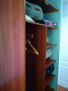 a closet with a wooden door and some clothes at Departamentos Egaña in Puerto Montt