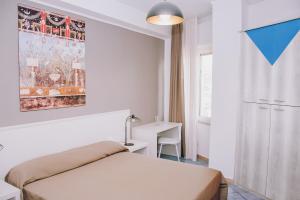 a bedroom with a bed and a desk and a window at Hotel Piccolo Sogno in Pompei