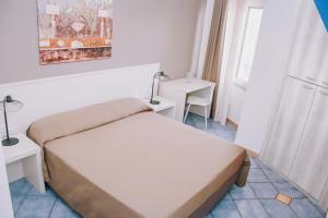 una piccola camera con letto e tavolo di Hotel Piccolo Sogno a Pompei