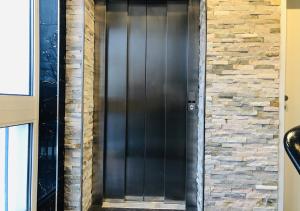 a black front door with a brick wall at Elbgalerie Hotel in Hamburg