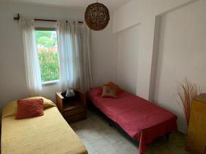 2 camas en una habitación con ventana en Depto GABIOLA - SOLO FAMILIAS -hasta para 4 pers- EXCELENTE UBICACION! en Villa Carlos Paz