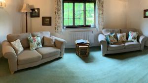 a living room with two couches and a table at Mill House - Devon Holiday Accommodation in Sidmouth