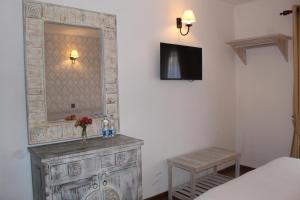 um quarto com uma cómoda com um espelho e uma cama em Grace em Nuwara Eliya