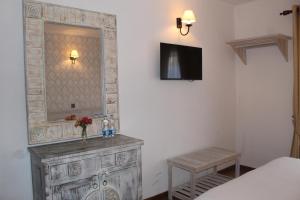 a bedroom with a dresser with a mirror and a bed at Grace in Nuwara Eliya