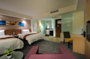 a hotel room with two beds and a television at Hoya Resort Hotel in Hualien City