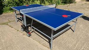 eine Tischtennisplatte mit Tischtennisball darauf in der Unterkunft Shippen Cottage - Perfect for Couples or Families in Sidmouth