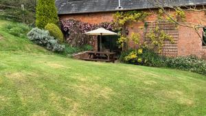 einen Picknicktisch mit Sonnenschirm im Garten in der Unterkunft Shippen Cottage - Perfect for Couples or Families in Sidmouth