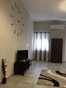 uma sala de estar com um grande relógio na parede em Meteora House- Cozy Living em Kalabaka