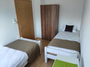 a small room with two beds and a cabinet at Four Seasons Apartment Josef in Eisenerz