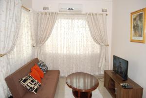 a living room with a couch and a window at Lonjeta Self-Catering Apartments in Lilongwe
