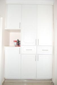 a white closet with white cabinets in a room at Lonjeta Self-Catering Apartments in Lilongwe