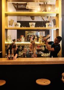 a group of people sitting at a bar at La Vaina Cali in Cali