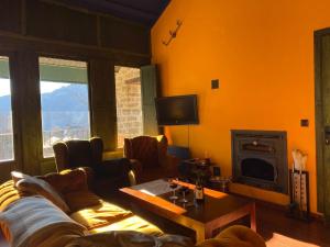 - un salon avec un canapé et une cheminée dans l'établissement Apartamento ático-dúplex en Casa Rural Fundanal en Hoz de Jaca, à Hoz de Jaca