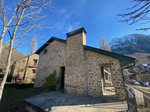 ein Backsteingebäude mit einem Kamin darüber in der Unterkunft Apartamento ático-dúplex en Casa Rural Fundanal en Hoz de Jaca in Hoz de Jaca