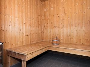 a wooden bench in a sauna with a bucket at 8 person holiday home in R m in Bolilmark
