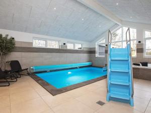 a large swimming pool in a living room with a blue at 14 person holiday home in Str by in Strøby