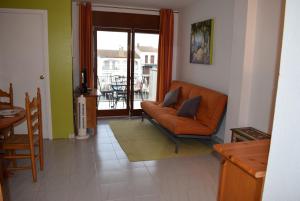 ein Wohnzimmer mit einem orangenen Sofa und einem Balkon in der Unterkunft Apartamento con bonitas vistas al canal ref 337 in Empuriabrava