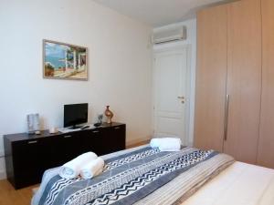 1 dormitorio con 1 cama, escritorio y TV en Taormina Panoramic - Taormina Holidays, en Taormina