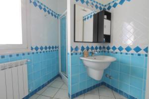 a blue bathroom with a sink and a mirror at Taormina Panoramic - Taormina Holidays in Taormina +21 photos