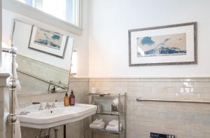 a white bathroom with a sink and a mirror at Public House Lofts in Crested Butte +17 photos