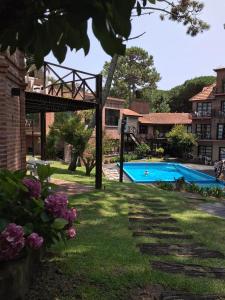 un patio con piscina y un edificio en Cariló Paradise Apart Hotel & Spa en Cariló