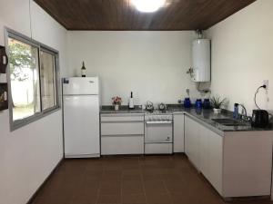 cocina con electrodomésticos blancos y ventana grande en La Soñada en Lobos
