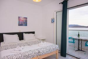 a bedroom with a bed and a table and a window at Hiona Apartments in Elounda