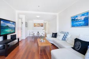 a living room with a white couch and a table at Perfect Pyrmont penthouse with Sydney Tower View in Sydney