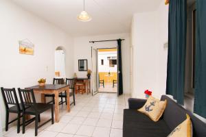 - un salon avec un canapé, une table et des chaises dans l'établissement Hiona Apartments, à Elounda
