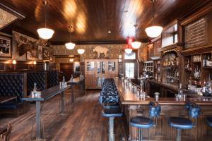 bar z drewnianymi podłogami i stołkami barowymi w obiekcie Public House Lofts w mieście Crested Butte