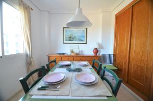 een eetkamer met een tafel met stoelen en een lamp bij 055 Paradise Vacation - AC/WIFI in La Mata