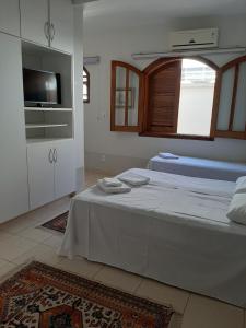 a white room with a bed and a tv at Pousada Santa Fé in Aparecida