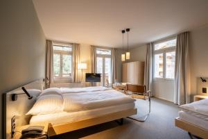 a bedroom with a large bed and a desk at Hotel Alpenruhe - Vintage Design Hotel in Wengen