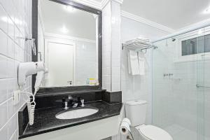 a bathroom with a sink and a toilet and a mirror at Slim Hotel São Paulo Congonhas in São Paulo