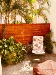 une chaise devant une clôture en bois avec des plantes dans l'établissement Luna Creciente, à Santa Cruz Huatulco