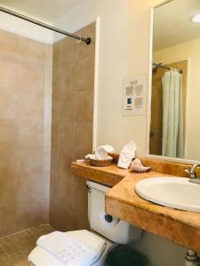 een badkamer met een wastafel, een toilet en een spiegel bij Luna Creciente in Santa Cruz Huatulco