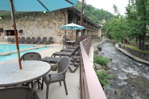 a patio area with tables, chairs and umbrellas at Greystone Lodge on the River in Gatlinburg