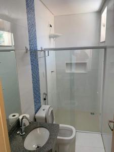 a bathroom with a toilet and a sink and a shower at Summit Pousada Noah in Maceió