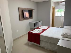 1 dormitorio con 1 cama con toallas en Summit Pousada Noah, en Maceió