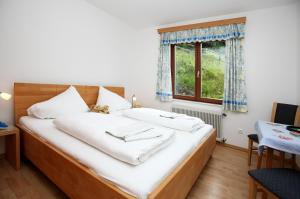 a bedroom with a bed with white sheets and a window at Villa Margarethe in Millstatt