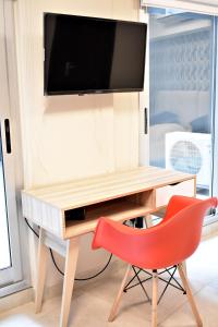 einen Schreibtisch mit einem TV und einem roten Stuhl in der Unterkunft Loft para 4 personas 1º C in Buenos Aires